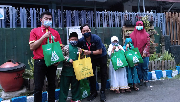 Perwakilan Alfamart menyerahkan paket sembako yang bersumber dari dana donasi konsumen kepada masyarakat yang membutuhkan. (FOTO: Dok Alfamart)