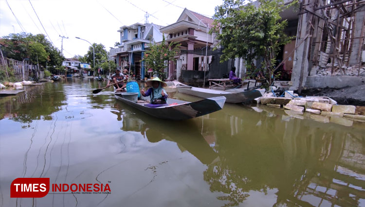 Warga yang berada di kawasan bengawan Njero Lamongan, menggunakan perahu sebagai alat transportasi, lantaran jalan umum terendam air. (FOTO: MFA Rohmatillah/ TIMES Indonesia)