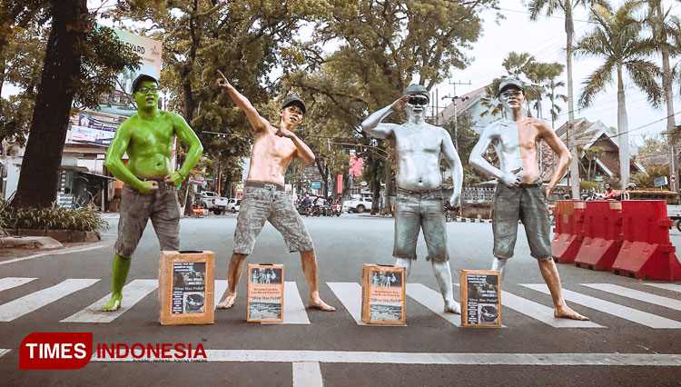 Silver man yang terdiri dari 4 anggota keluarga saat melakukan aksi galang dana di perempatan Jalan Ijen, Kota Malang, Minggu (24/01/2021). (Foto: Rizky Kurniawan Pratama/TIMES Indonesia)