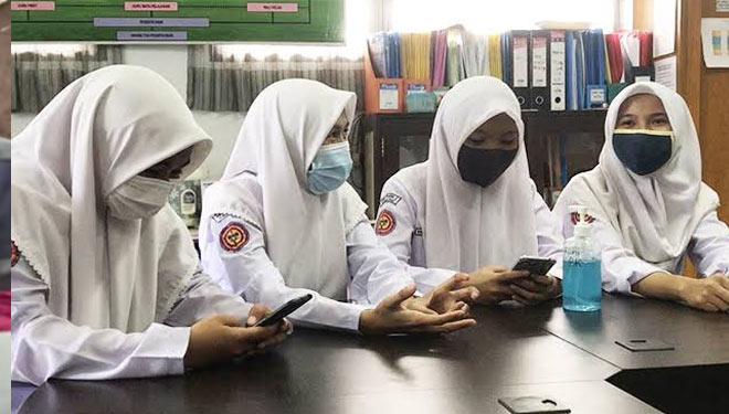 Siswi-siswi non muslim yang menggunakan jilbab. Mereka mengaku, pihak sekolah tidak pernah memaksa agar mereka menggunakan jilbab tersebut. (FOTO: Indeks News)