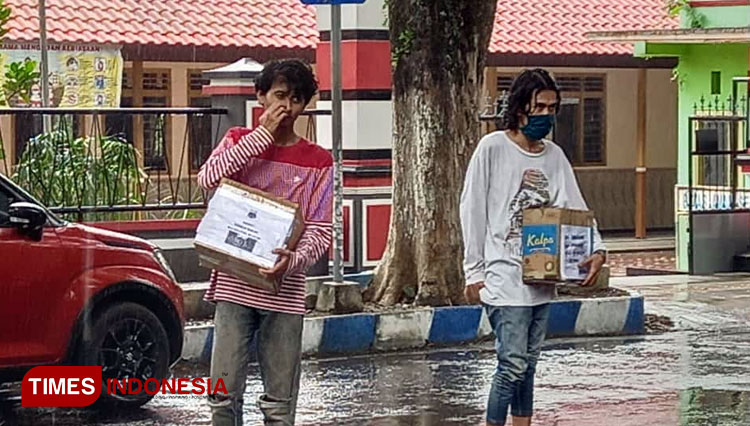 Meski diguyur hujan aktivis Mahasiswa PMII At-Taqwa Bondowoso tetap semangat menggalang sna untuk korban banjir di Kalimantan Selatan. (FOTO: Moh Bahri/TIMES Indonesia).