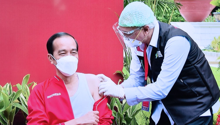 Presiden RI Jokowi saat disuntik vaksin Covid-19 Sinovac ke dua kalinya di Istana negara. Terlihat Kepala Negara mengenakan singlet dan jaket berwarna merah. (FOTO: Setkab RI)