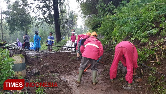 Petugas BPBD Kota Batu membersihkan tanah longsor jalan Dusun Toyomerto, Desa Pesanggrahan bersama-sama warga. (BPBD Kota Batu for TIMESINDONESIA)