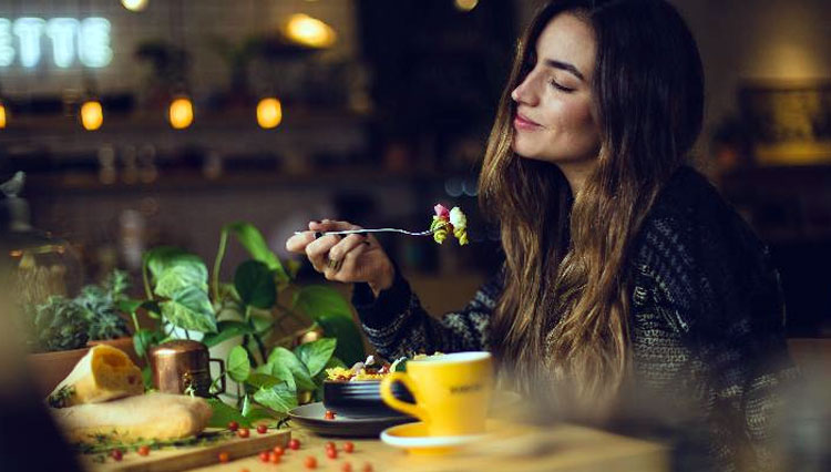 Ilustrasi - Seorang wanita sedang menikmati makanan (FOTO: Unsplash/Pablo Merchan)