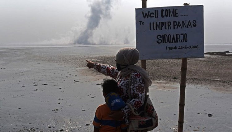 Korban lumpur Lapindo saat menunjuk pusat semburan dari titik 25 tanggul penahan lumpur Lapindo saat aksi memperingati 12 tahun semburan lumpur Lapindo di Porong, Sidoarjo, Jawa Timur (FOTO: Antarafoto/Zabur Karuru)