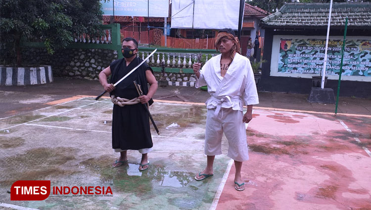 Anggota koramil yang tengah membagikan masker dengan memakai kostum pendekar di Kecamatan Wonosalam, Jombang. (FOTO: Serka Sari for TIMES Indonesia)