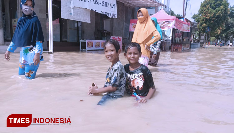 Anak-anak saat asyik bermain air banjir di Indramayu. (Foto: Muhamad Jupri/TIMES Indonesia)