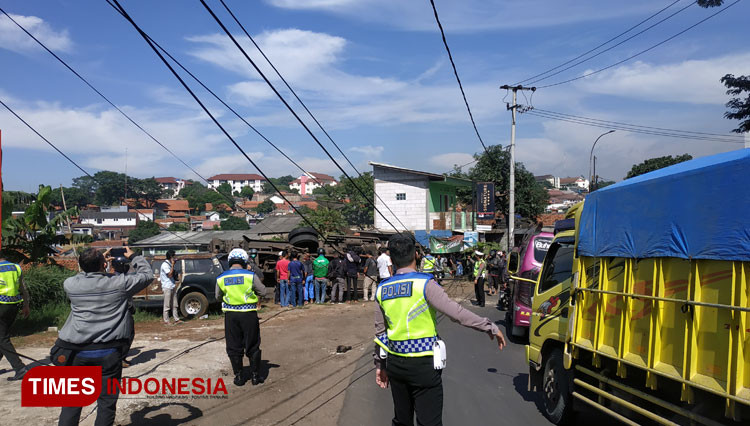 Sebuah truk tronton bermuatan batubara terguling di tikungan Cikuda Jatinangor. (FOTO: Alan Dahlan/TIMES Indonesia)