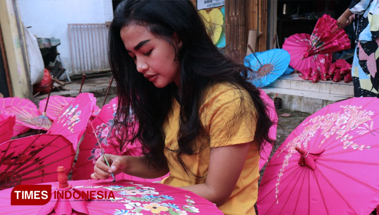 Sheni Martiani (21) melukis payung geulis di area penjemuran rumah produksi di Kampung Panyingkiran, Kecamatan Indihiang, Kota Tasikmalaya (FOTO: Harniwan Obech/TIMES Indonesia)