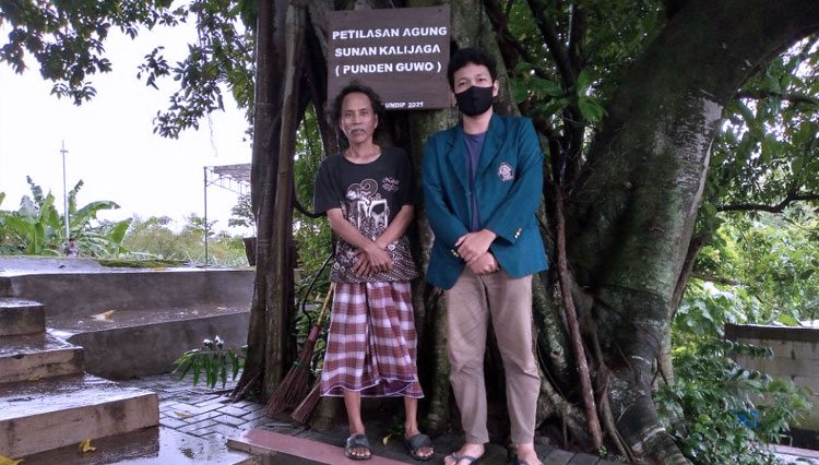 Mahasiswa KKN Undip, Imam Firmanullah memberikan papan nama pada situs peninggalan sejarah di Kelurahan Sendangguwo, Semarang, Rabu (17/2/2021). (Foto: Dok Undip)