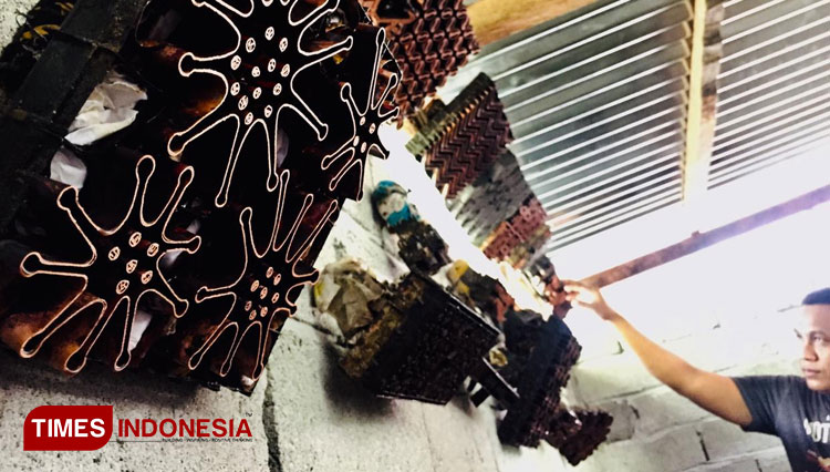 Pengrajin Batik Waliri, Afrianto saat menyusun cetakan batik virus corona dan berbagai motif lainnya. (Foto : Nurlela for Times Indonesia)