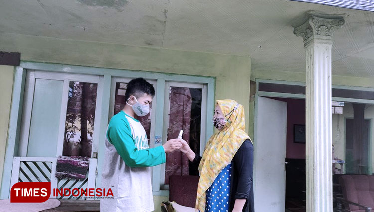 Alvin Rikza Herdani, membagikan Handsanitizer kepada warga Desa Dampit (FOTO: AJP/TIMES Indonesia)
