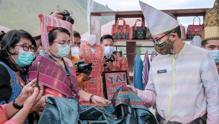 Menteri Pariwisata Sandiaga Uno saat melihat kain Ulos yang merupakan produk lokal di ajang #BeliKreatifDanauToba. (foto: Kemenparekraf RI)