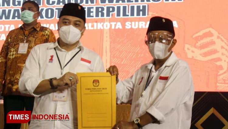 Eri Cahyadi dan Armuji menunjukkan berkas penetapan pemenang Pilwali Surabaya 2020. (Foto: Ammar Ramzi/Times Indonesia)