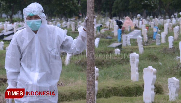Petugas makam di Surabaya mengenakan APD lengkap usai menguburkan jenazah pasien Covid-19. (Foto: Adhitya Hendra/TIMES Indonesia)