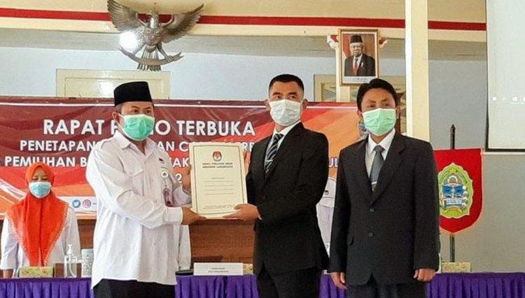 Ketua KPU Gunungkidul Ahmadi Ruslan Hani (kiri) memberikan SK Penetapan pada pasangan calon (paslon) terpilih Pilkada 2020, Sunaryanta-Heri Susanto pada Jumat (22/01/2021). (Foto: Tribunjogja/Alexander Ermando)
