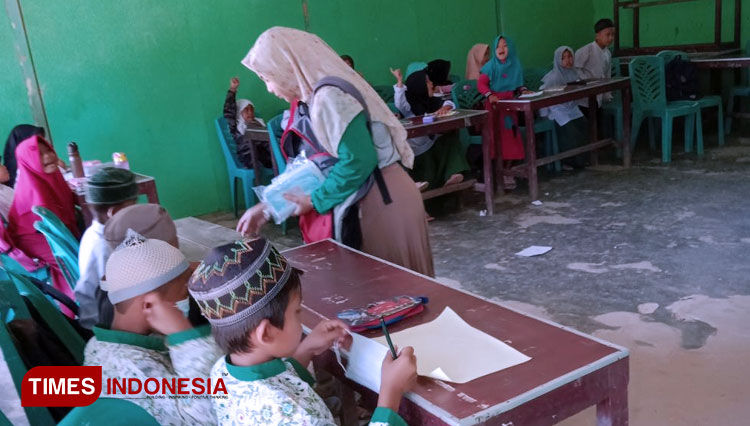 Mahasiswa KSM-Unisma Kelompok 34 membagikan masker dan poster bertema covid-19 kepada murid MDTA Thariqul Huda. (FOTO: AJP TIMES Indonesia)