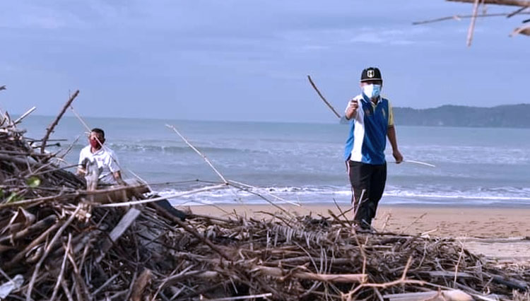 Bupati Pacitan, Indartato saat membersihkan sampah di Pantai Pancerdor Pacitan. (FOTO: Dok. Humas Pemkab. Pacitan)