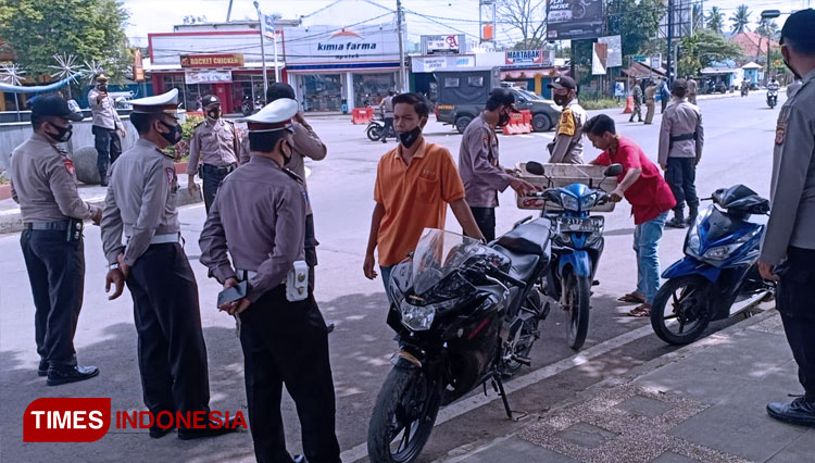 Petugas gabungan melakukan razia terhadap masyarakat yang tidak pakai masker. (FOTO: Syamsul Ma'arif/TIMES Indonesia)