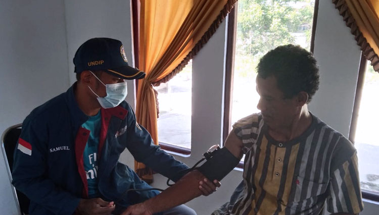 Mahasiswa KKN Undip, Henry Salenussa melakukan pemeriksaan darah tinggi pada warga di Seram Bagian Barat, Maluku. (Foto: Dok. Undip)