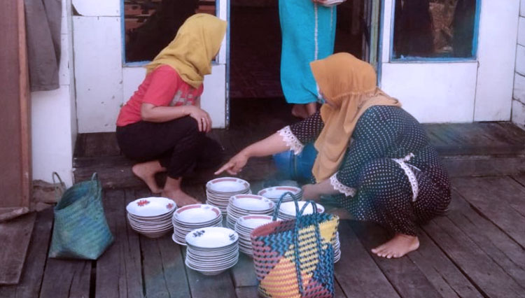 Warga Sedang Menyiapkan Piring untuk Makan Siang. (FOTO: AJP TIMES Indonesia)
