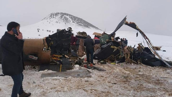 Petugas penyelamat, tentara, dan warga sipil berjalan di sekitar reruntuhan helikopter militer yang jatuh di dekat kota Bitlis di Turki timur (FOTO/Al Jazeera/AFP).