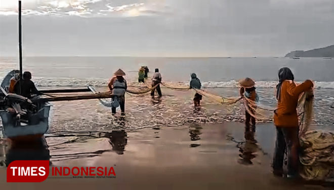 Aktivitas nelayan di pantai timur Pangandaran sedang menarik jaring arad. (Foto: Syamsul Ma'arif/TIMES Indonesia)