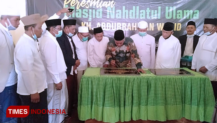 Kiai Marzuki Mustamar (baju batik) menandatangani prasati Masjid Gus Dur di Plosowahyu, Lamongan. (foto: Kades Plosowahyu for TIMES Indonesia)
