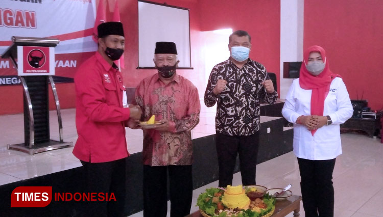 Ketua DPC PDI Perjuangan Banjarnegara H Nuryanto serahkan tumpeng kepada tokoh senior PNI, Sukamto. (FOTO: Muchlas: Hamidi TIMES Indonesia)