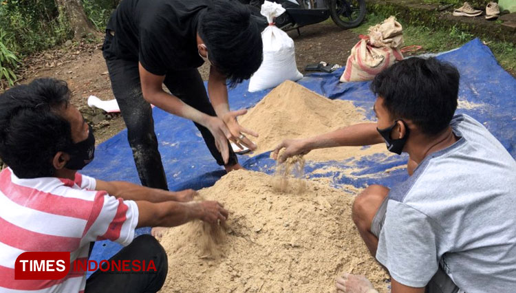 Mahasiswa UM Jember tengah mengolah limbah kulit singkong menjadi pakan ternak di Dusun Mojan. (FOTO: AJP TIMES Indonesia)