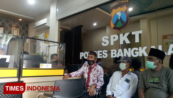 Anggota DPRD Kabupaten Bangkalan, H Musawwir (pakaian batik) mendatangi SPKT Polres Bangkalan untuk melaporkan ancaman pembunuhan yang dilakukan oknum kades. (Foto: Doni Heriyanto/TIMES Indonesia)