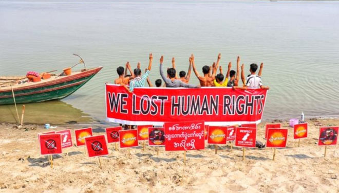 Para pengunjuk rasa di Nyaung-U, Myanmar berpartisipasi dalam tiruan tenggelam sebagai sinyal kepada dunia bahwa negara mereka perlu diselamatkan. (FOTO: Reuters)