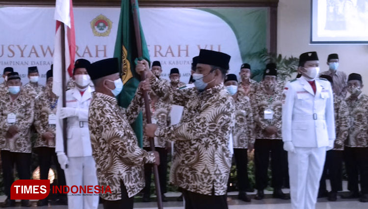 KH Abdul Muiz saat menerima bendera saat Musda VII LDII Gresik (FOTO: Akmal/TIMES Indonesia)