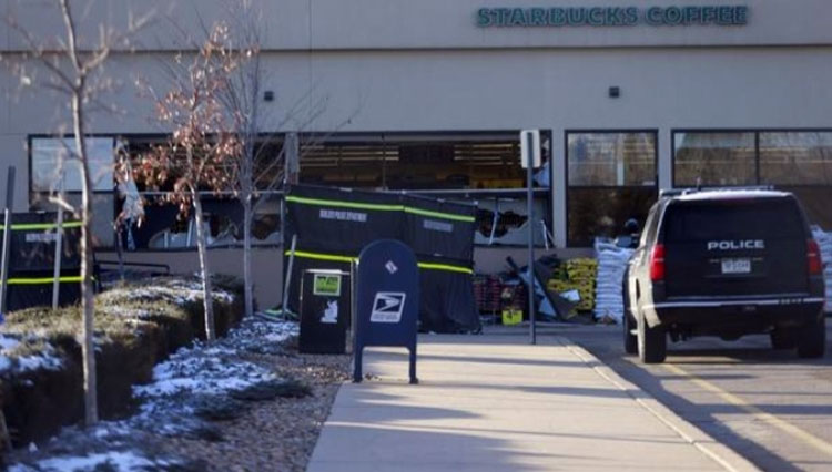 Pagi hari setelah penembakan massal terjadi,  toko grosir King Soopers, di Boulder, Colorado, AS tampak mengalami kerusakan dan orang-orang yang meletakkan karangan bunga. (FOTO:Reuters)
