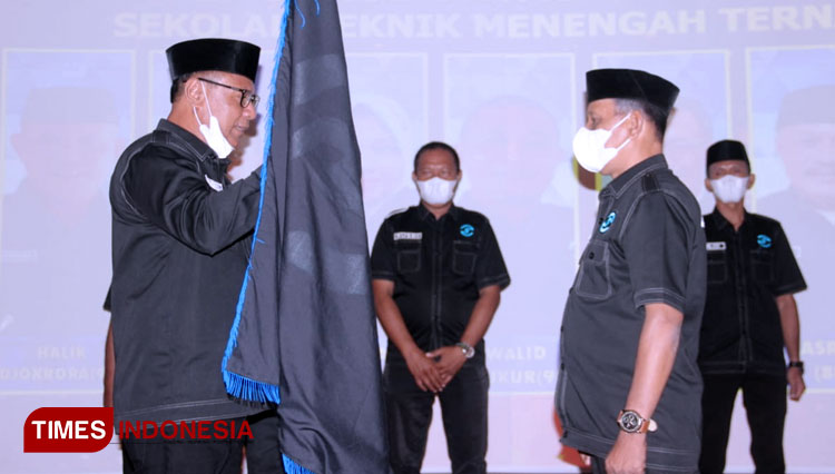 Ketua Dewan Pembina Yayasan Alumni STM Ternate, Muhammad Senen menyerahkan bendera alumni kepada Ketua Yayasan, Halik Djokrora. (Foto: Wahyudi Yahya/TIMES Indonesia)