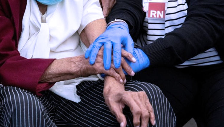 Bernice Bohannon, 111, dihibur perawat setelah vaksinasi Covid-19 di IU Health Neuroscience Center di Indianapolis, Indiana, Amerika Serikat, dan Brasil yang menggali lebih banyak lobang pemakaman rakyatnya. (FOTO: Reuters)