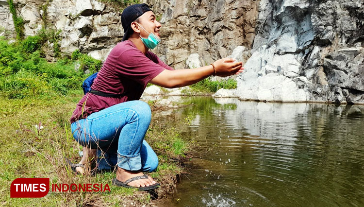 Salah seorang pengunjung tampak asyik bermain air di Cadas Gantung. (Foto: Susi/TIMES Indonesia)