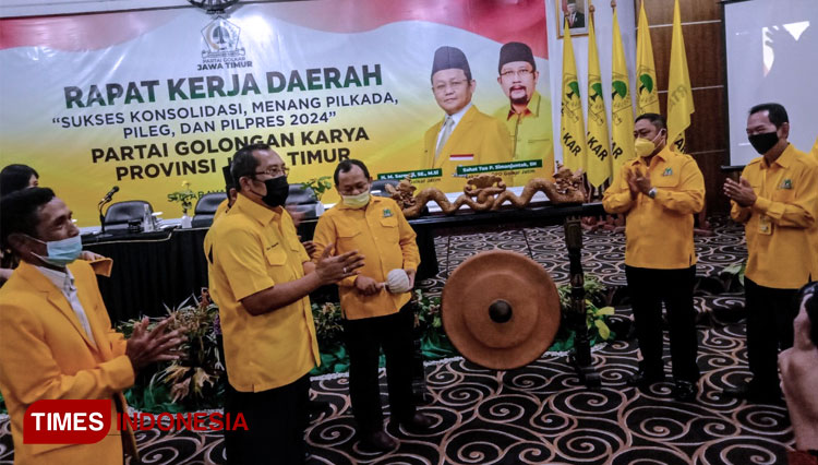 Didampingi Sekretaris Sahat Tua Simanjuntak, Ketua Golkar Jatim M. Sarmuji memukul gong tanda dimulainya Rakerda dan Rapimda Golkar Jatim, Rabu (31/3/2021). (FOTO: Lely Yuana/TIMES Indonesia) 
