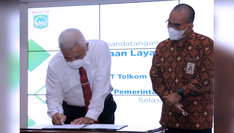 Bupati Malang Abah Sanusi ketika menandatangani kerjasama dengan Telkom. (FOTO: Humas Pemkab Malang)