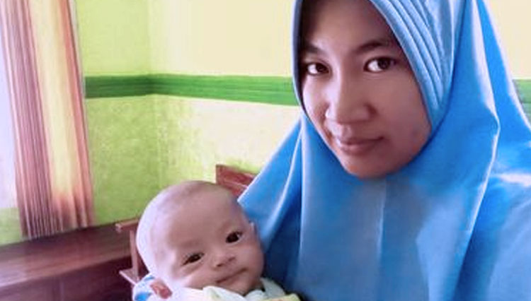 Ririn Linda Tunggal Sari (33), saat menggendong anaknya yang diberi nama Dinas Komunikasi Informatika Statistik. (FOTO: Kompas.com)
