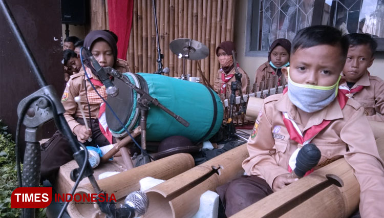 Para murid Madrasah Ibtidaiyah Pesawahan memainkan alat musik tradisional Ciamis, Dongkur. (Foto: Natasya/TIMES Indonesia)
