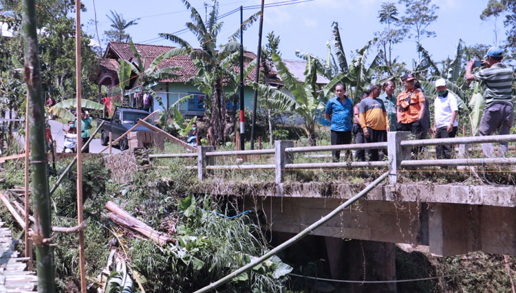 Bupati Banjarnegara Budhi Sarwono saat meninjau jembatan Kali Bojong yang tiangnya ambrol diterjang banjir. (FOTO: Kominfo for TIMES Indonesia)