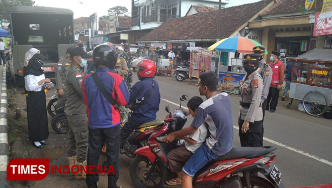 Kapolsek Rajadesa dan tim gabungan sedang memantau warga yang tidak memakai masker di kawasan pasar Rajadesa (foto: Humas Polres Ciamis)