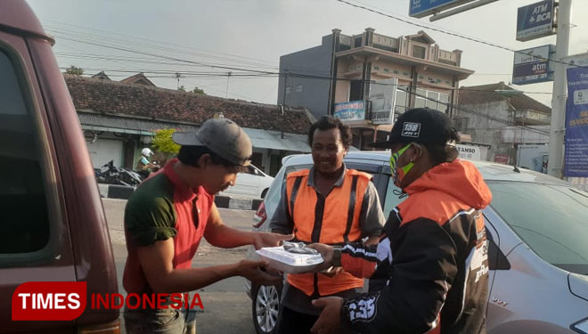 Pengurus Jabar Bergerak Majalengka membagikan nasi bungkus kepada warga. (Foto: Jaja Sumarja/TIMES Indonesia)