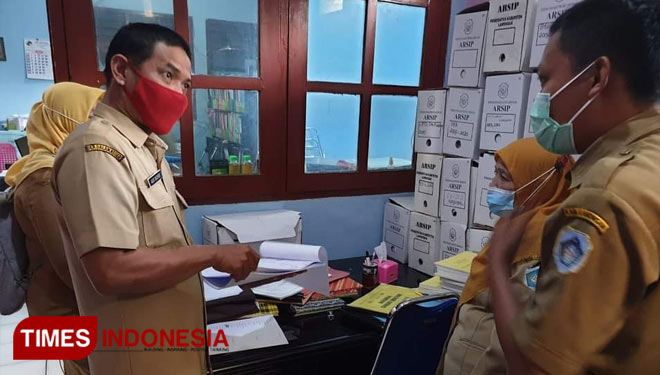 Agus Bukhori (memakai masker merah) Staf Dinas Kearsipan Lamongan saat melakukan audit Pengawasan Internal ke salah satu OPD di Lamongan, (Foto : Dokumen for TIMES Indonesia)