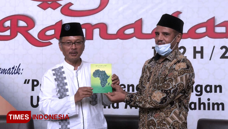 Prof. Abdul Haris, the Rector of UIN Malang taking the book given by Dr Sulaiman Alhasani of Libya. (Photo: Nadira Rahmasari/TIMES Indonesia)