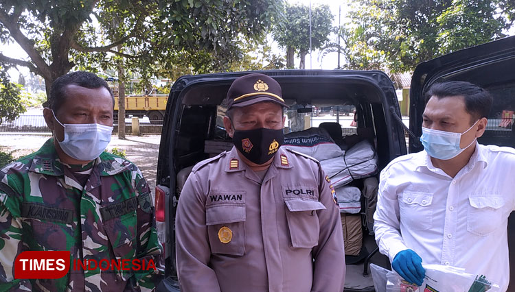 Kapolsek Ajibarang AKP Wawan Dwi Laksono dengan latar belakang petasan hasil operasi Penyekatan di Pos Ajibarang. (FOTO: Sutrisno/TIMES Indonesia)