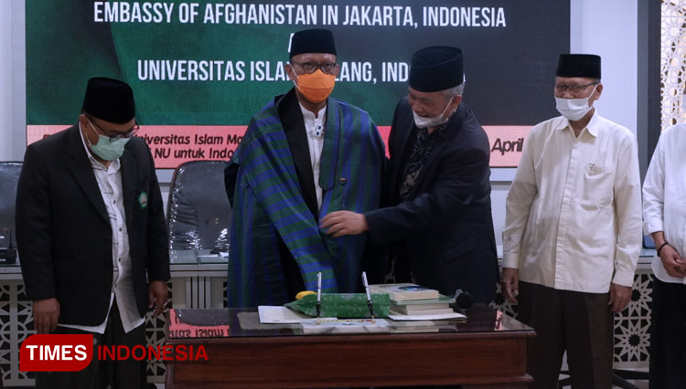 Duta Besar RI untuk Afghanistan Arief Rachman menyematkan jubah kebesaran Afghanistan kepada Rektor Unisma Prof Dr H Maskuri MSi. (Foto: Naufal Ardiansyah/TIMES Indonesia)