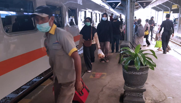Porter stasiun tengah membantu penumpang membawakan barang bawaan ke atas kereta. (Foto: Humas Daop 9 Jember for TIMES Indonesia)