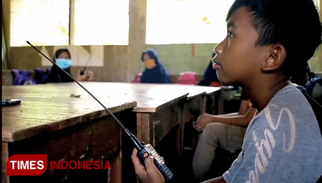 Murid di MI Pasawahan, Kecamatan Banjaranyar, Kabupaten Ciamis menggunakan Radio HT untuk belajar di masa pandemi (foto: Dok. Yayat)